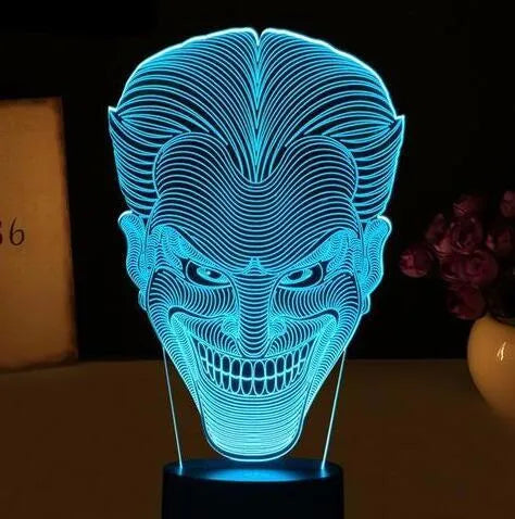 A 3D acrylic LED table lamp displaying colourful light patterns, with a remote control and USB cable.