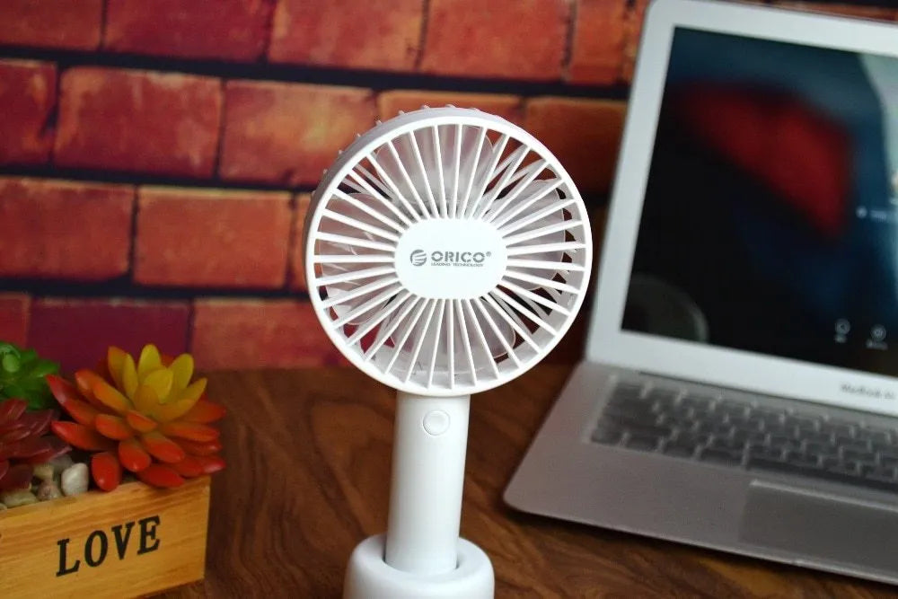 White ORICO FH1 portable USB rechargeable desk fan with three-speed buttons and a fine line pattern on its ABS shell.