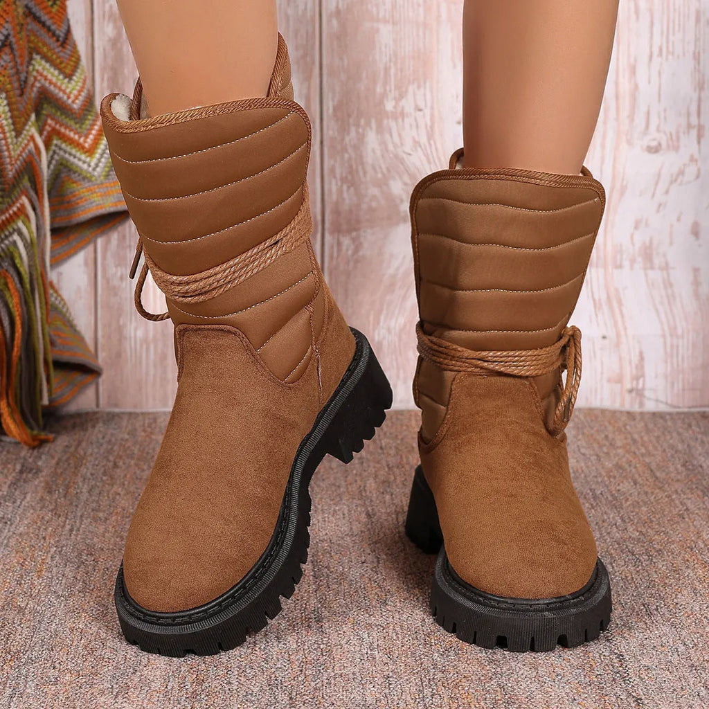 Black women's chunky heel snow boots with lace-up design and suede upper on a rubber sole