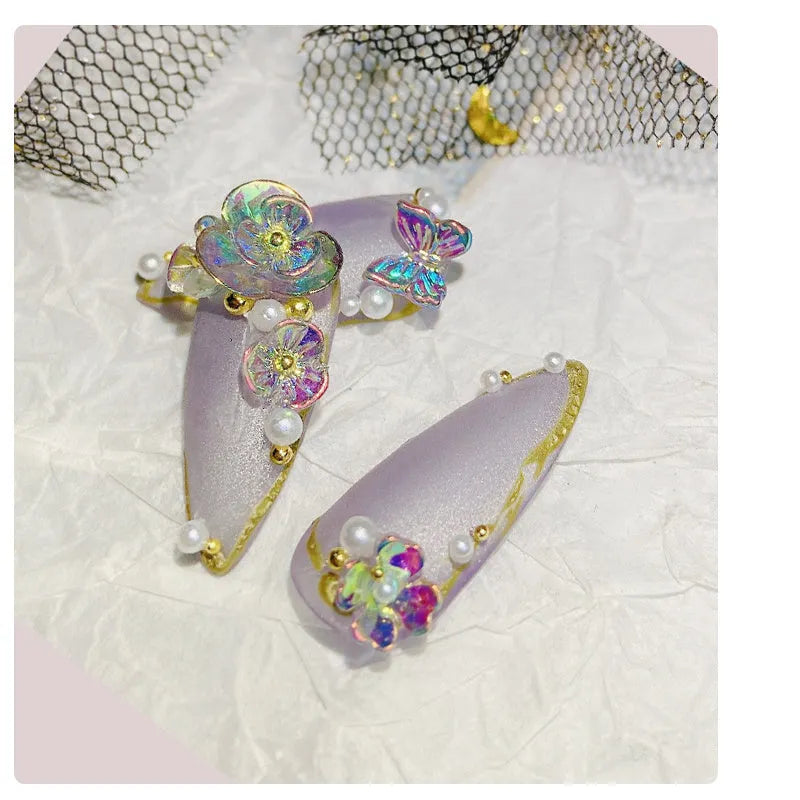 Container of flower and butterfly shaped nail sequins in mixed colours blue champagne grey pink transparent yellow