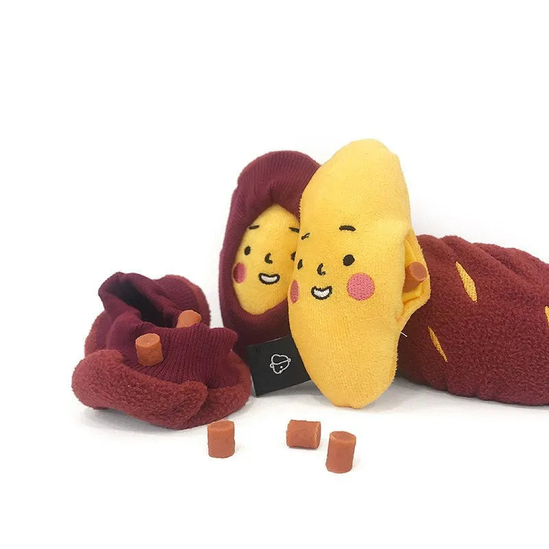 Red sweet potato-shaped dog toy with a peelable layer and hidden treat pocket for interactive play.