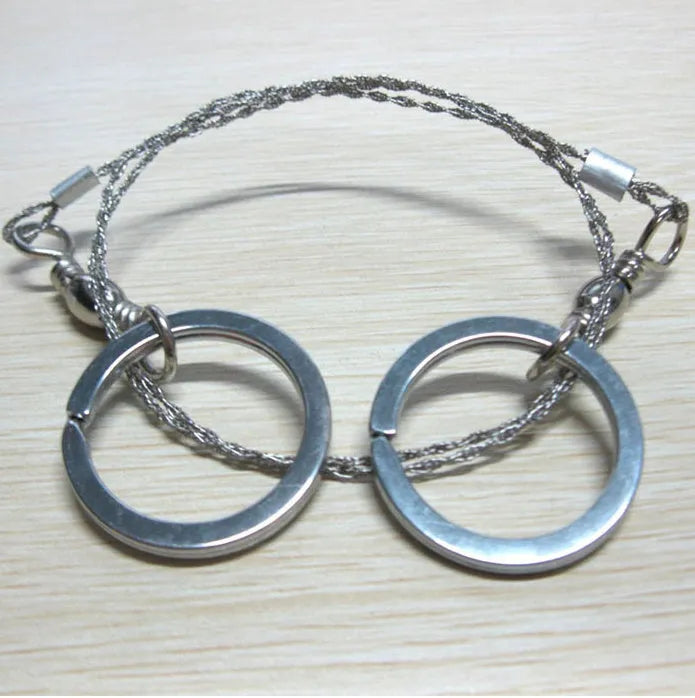Stainless steel survival wire saw with pull rings, showing coiled 55 cm blade.