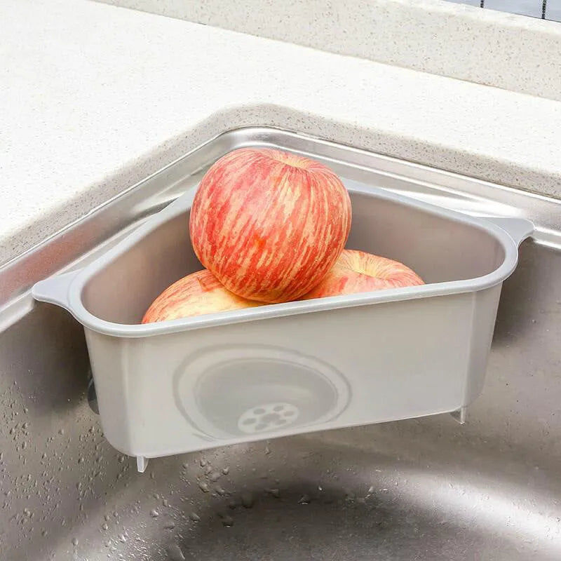 Beige plastic triangle sink storage rack for draining sponges, shown mounted on a kitchen faucet.