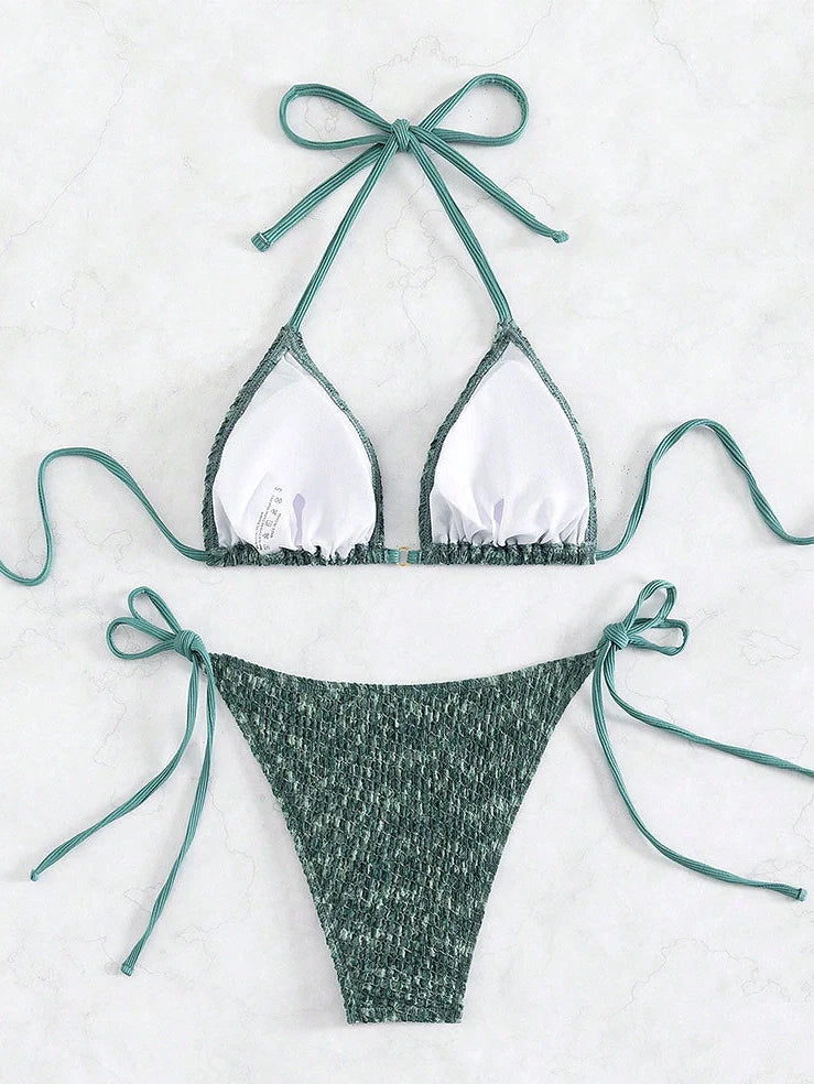 Green backless halter swimsuit with adjustable straps and matching shorts on mannequin