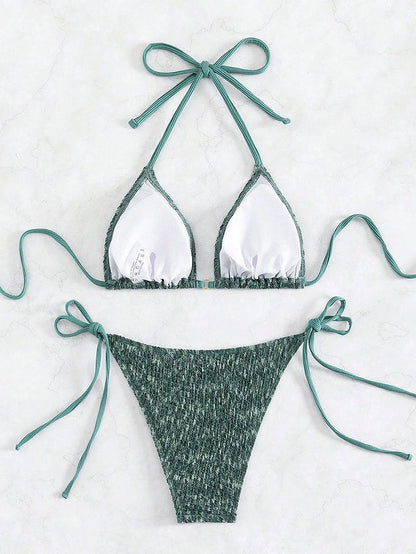 Green backless halter swimsuit with adjustable straps and matching shorts on mannequin