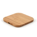 Square natural bamboo 5W QI wireless charging pad on a wooden surface.