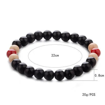 Natural stone beaded bracelet with a lava stone charm for essential oils on a wrist.