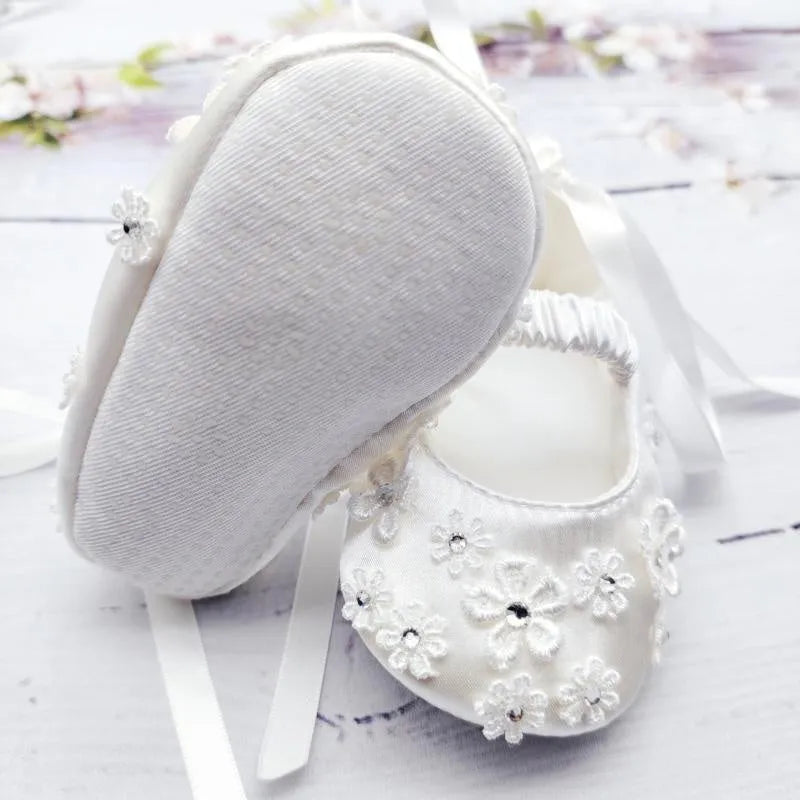 White baby soft bottom cloth princess shoes with rhinestone detail on a white background
