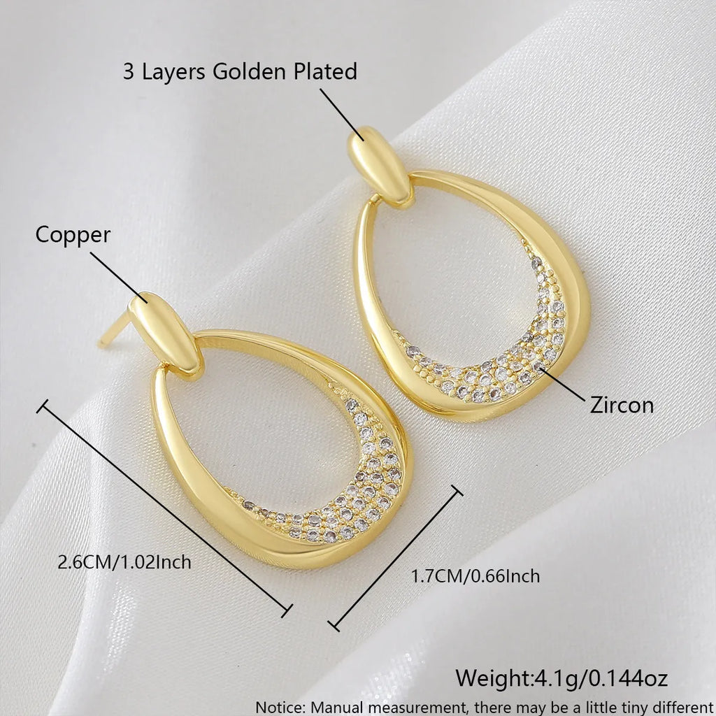 Yellow gold geometric drop-shaped women's earrings with round and oval ring elements on a simple background.