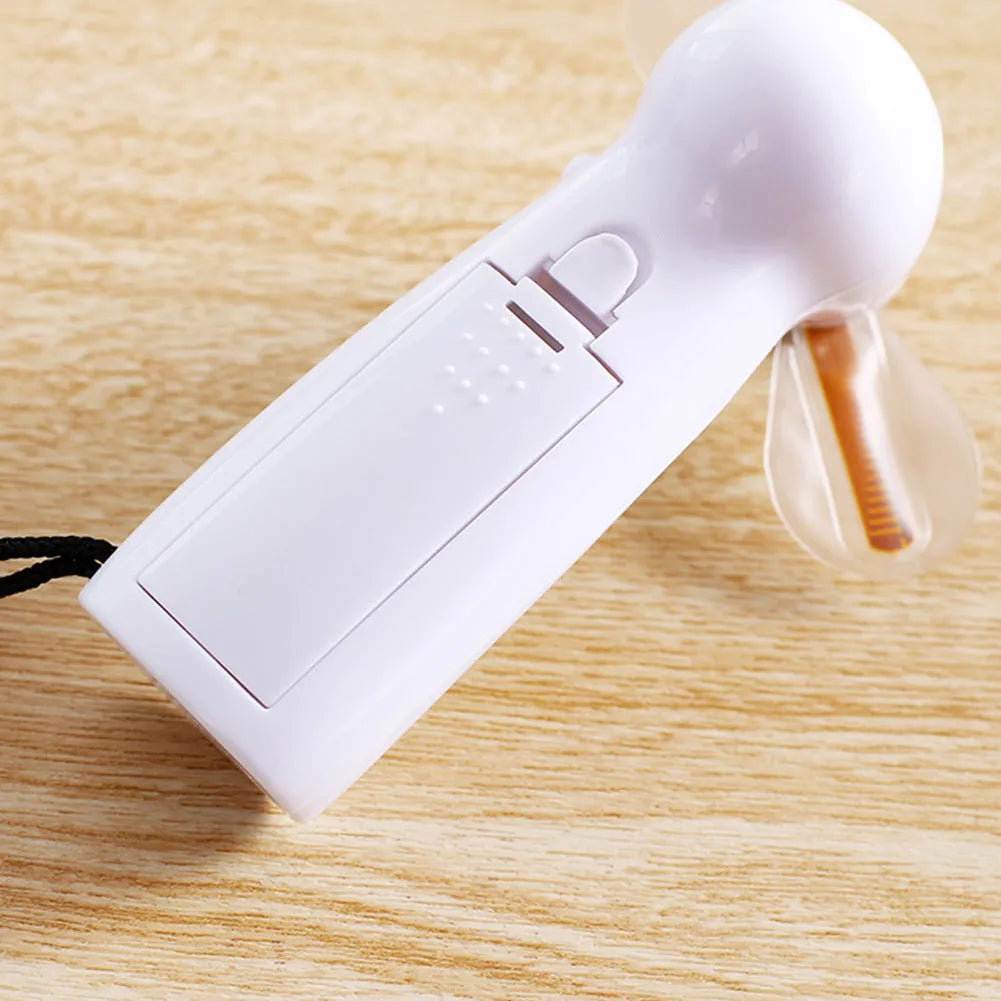 White handheld mini fan with a flashing LED love pattern display.