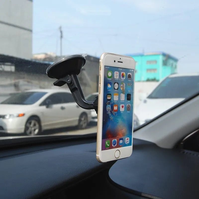 Black magnetic car phone holder mounted on dashboard with phone attached, showing 360-degree rotation capability