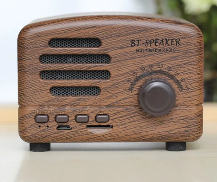 Vintage-style wood-effect Bluetooth speaker in black, pink, and wood grain colour options.