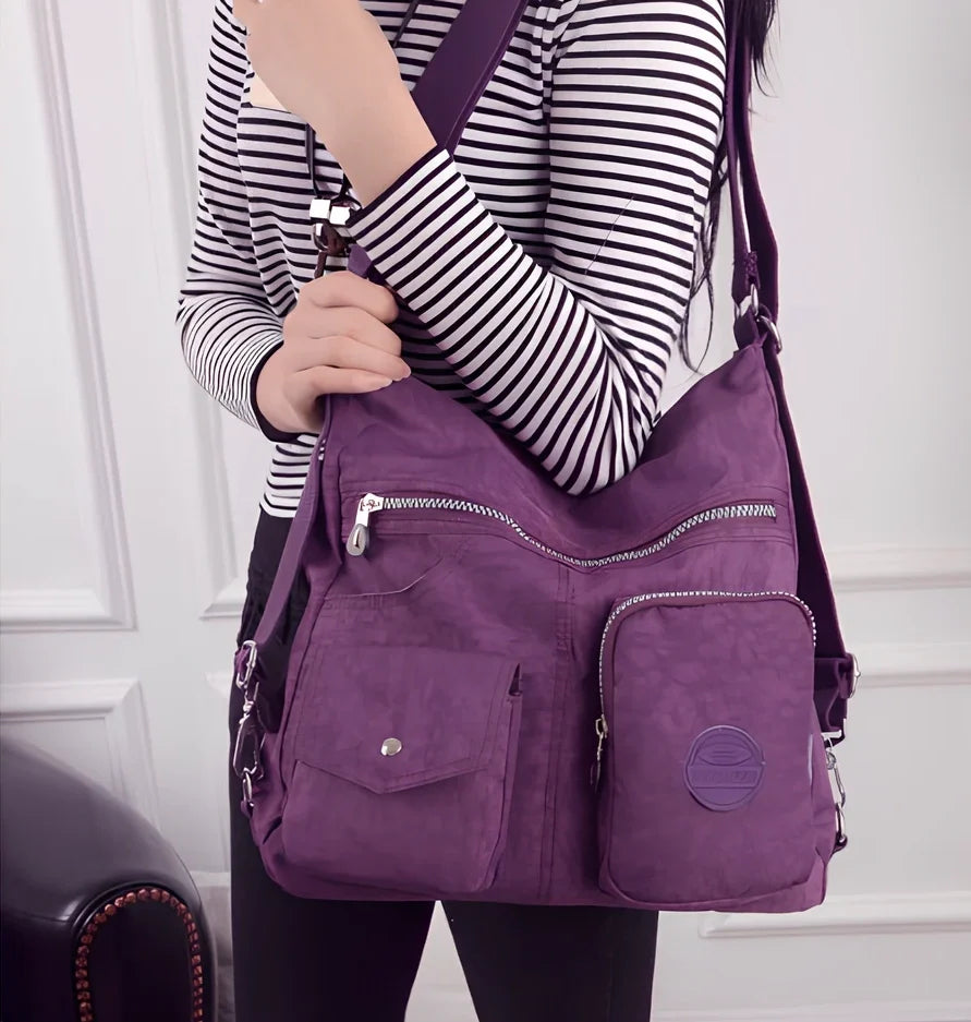 Women's waterproof nylon crossbody bag with organizational pockets and 34cm laptop capacity