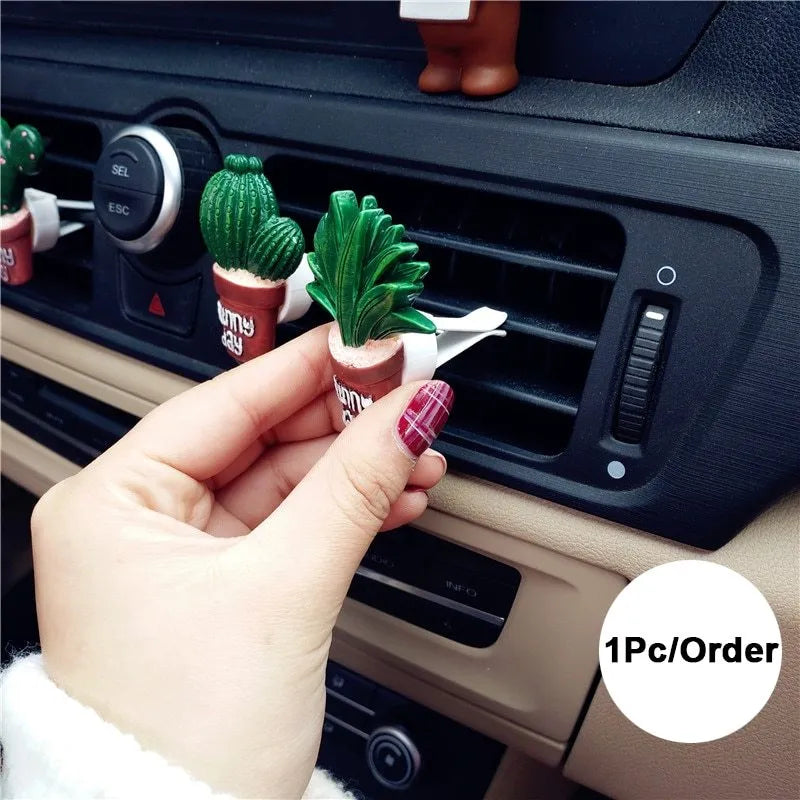 Car air freshener vent clip in plant ornament style, attached to car air conditioning vent