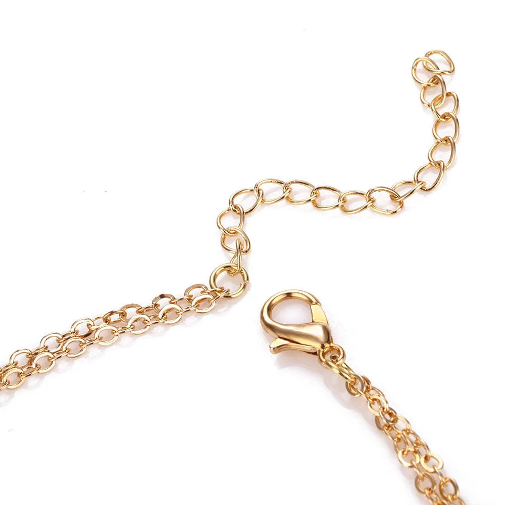 Gold multi-layer sequined choker necklace with drop pendant on woman's neck