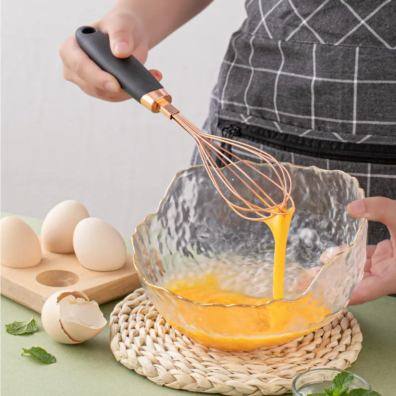 7-piece stainless steel kitchen tool set with copper plating in assorted colours on a countertop.