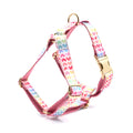 Pink colourful dog harness with gold buckle and heart-shaped stones on chest and back strap.