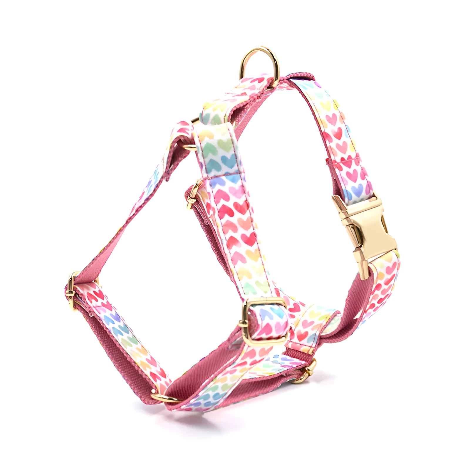 Pink colourful dog harness with gold buckle and heart-shaped stones on chest and back strap.