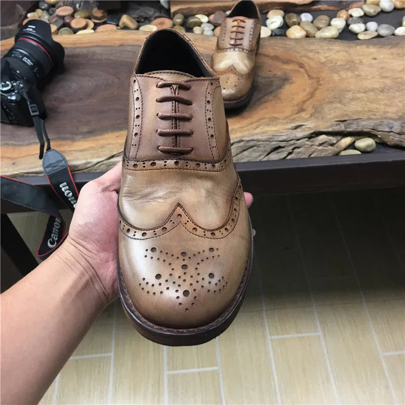 Men's light brown vintage distressed leather shoes with carved detail and round toe.