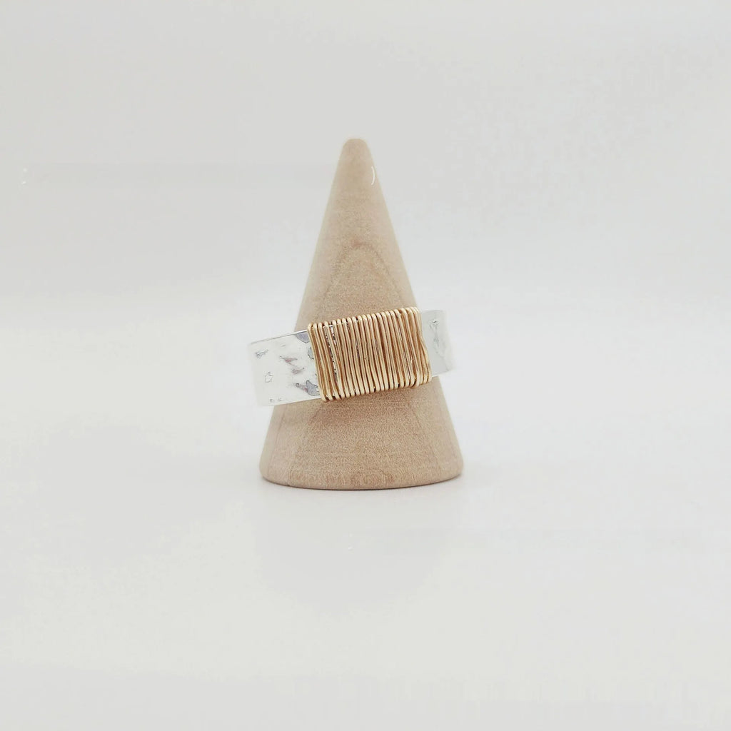 Silver golden geometric coil copper ring for men and women on a grey background.