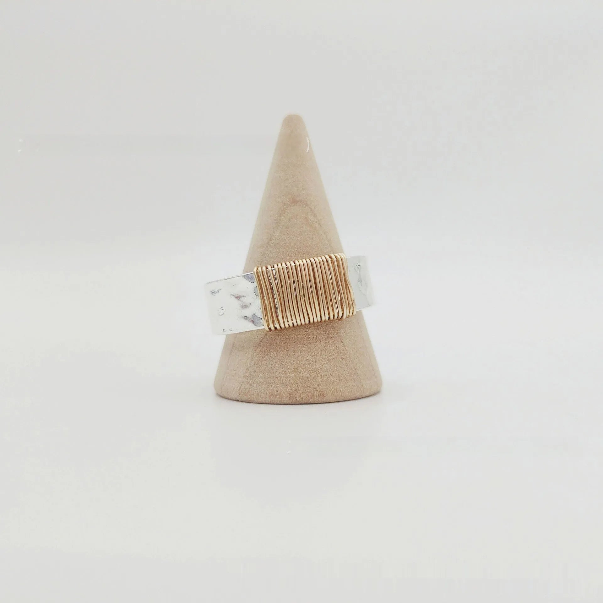 Silver golden geometric coil copper ring for men and women on a grey background.