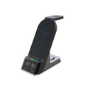 Black multifunctional wireless charging alarm clock with digital display and phone on charging pad.