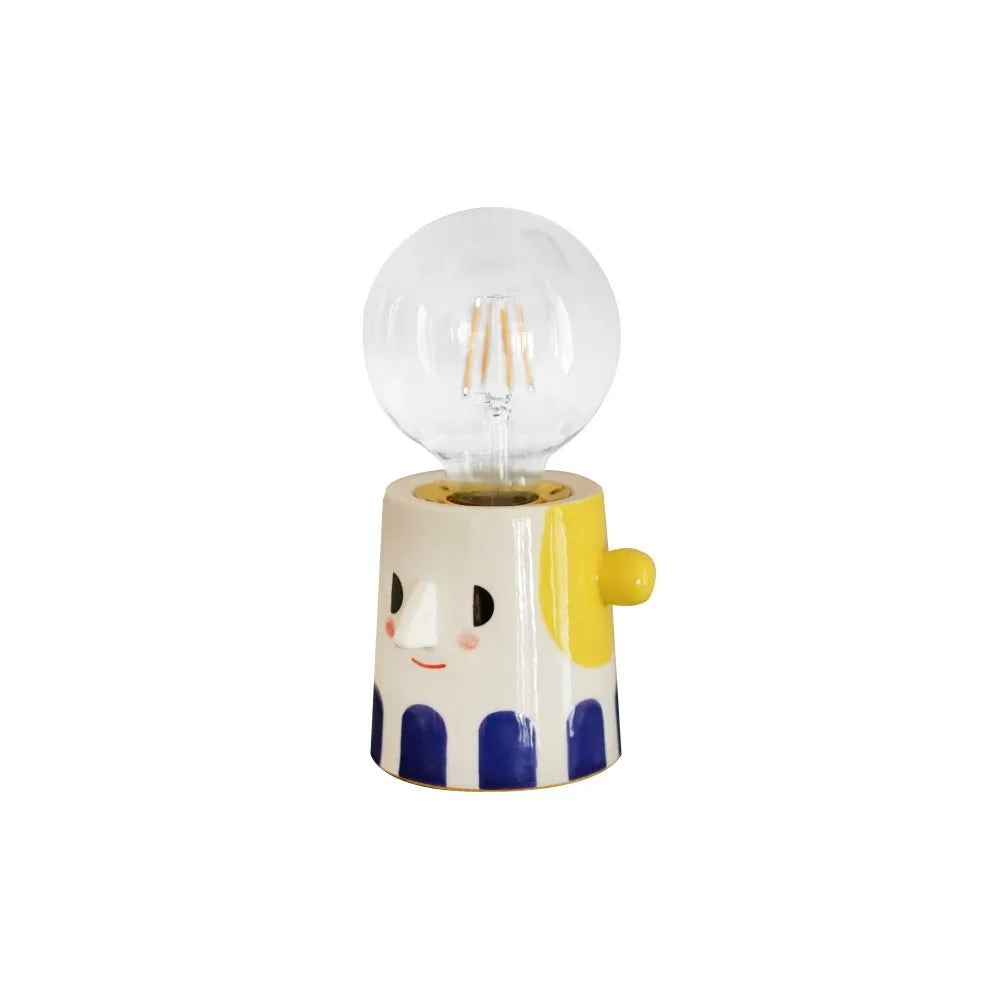 Handmade ceramic bedside lamp with a creative ball headlight design on a wooden table.