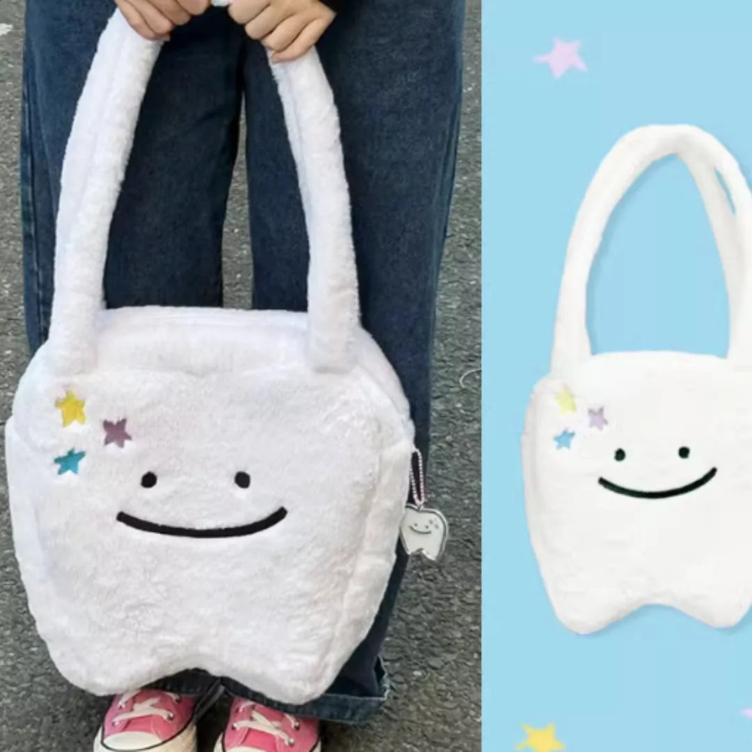 White plush tote bag with a cute teeth graphic, showing the crossbody strap and zipper opening.