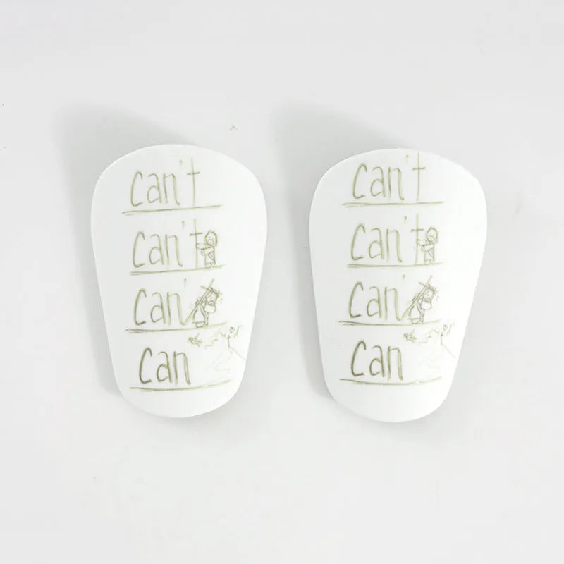 A pair of white PU football shin guards for adult training, showing the strap and protective shell.