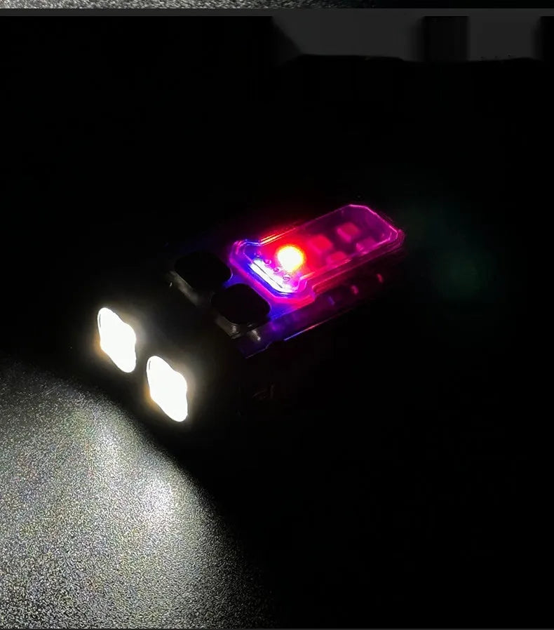 Black portable tactical mini warning flashlight with USB charging cable on a backpack strap.