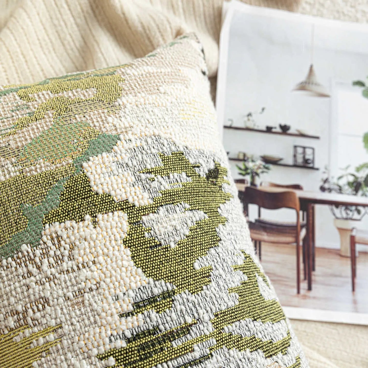 Green antique French style floral pattern wool blend decorative pillow on a sofa.