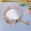 Pink crystal peace buckle bracelet on a metallic chain for women.