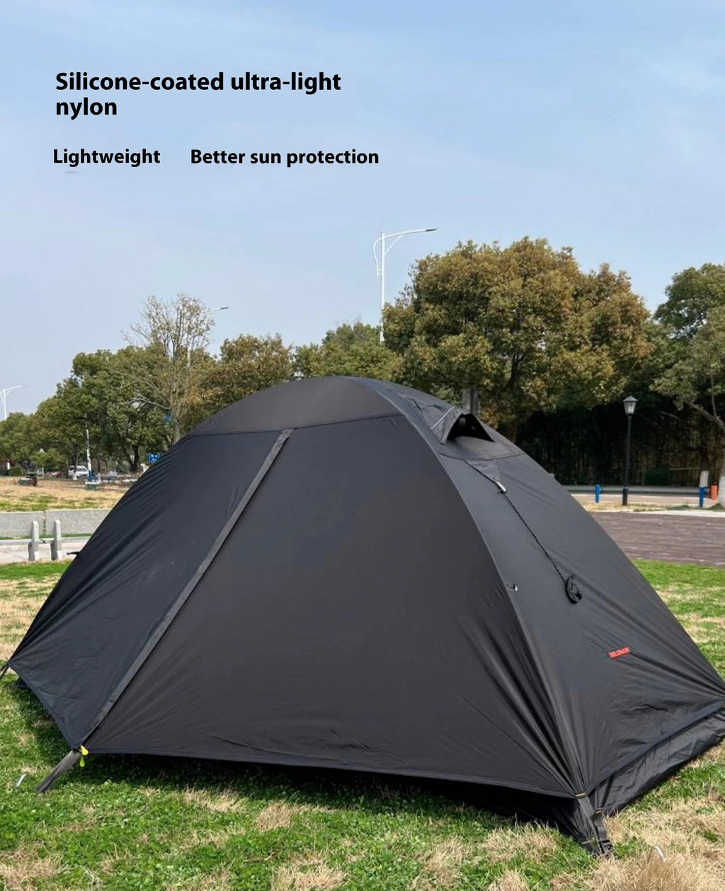 Lightweight red single person tent with aluminium poles pitched outdoors.