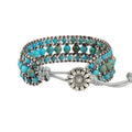 Handmade turquoise geometric inlaid gem bracelet in green with starry sky meteor shower pattern on a white background.