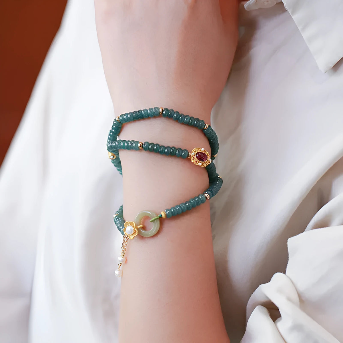 Blue water jade abacus bead bracelet with tourmaline and pearl accents on a wrist