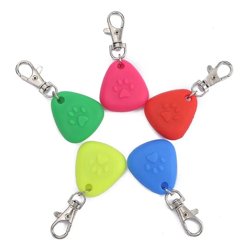 A glowing triangular silicone pendant ornament for pets, shown in various colours on card packaging.