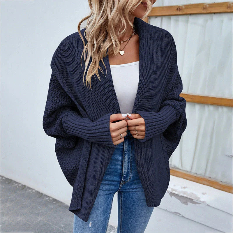 A cozy, oversized knit cardigan with a unique bat-wing sleeve design and large lapel, available in a variety of stylish colors.