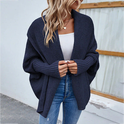 A cozy, oversized knit cardigan with a unique bat-wing sleeve design and large lapel, available in a variety of stylish colors.