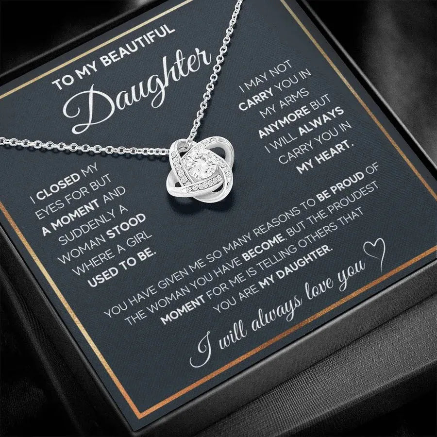Silver metal four-leaf clover hollow jeweled pendant clavicle chain on display with geometric shape and card beside flip gift box