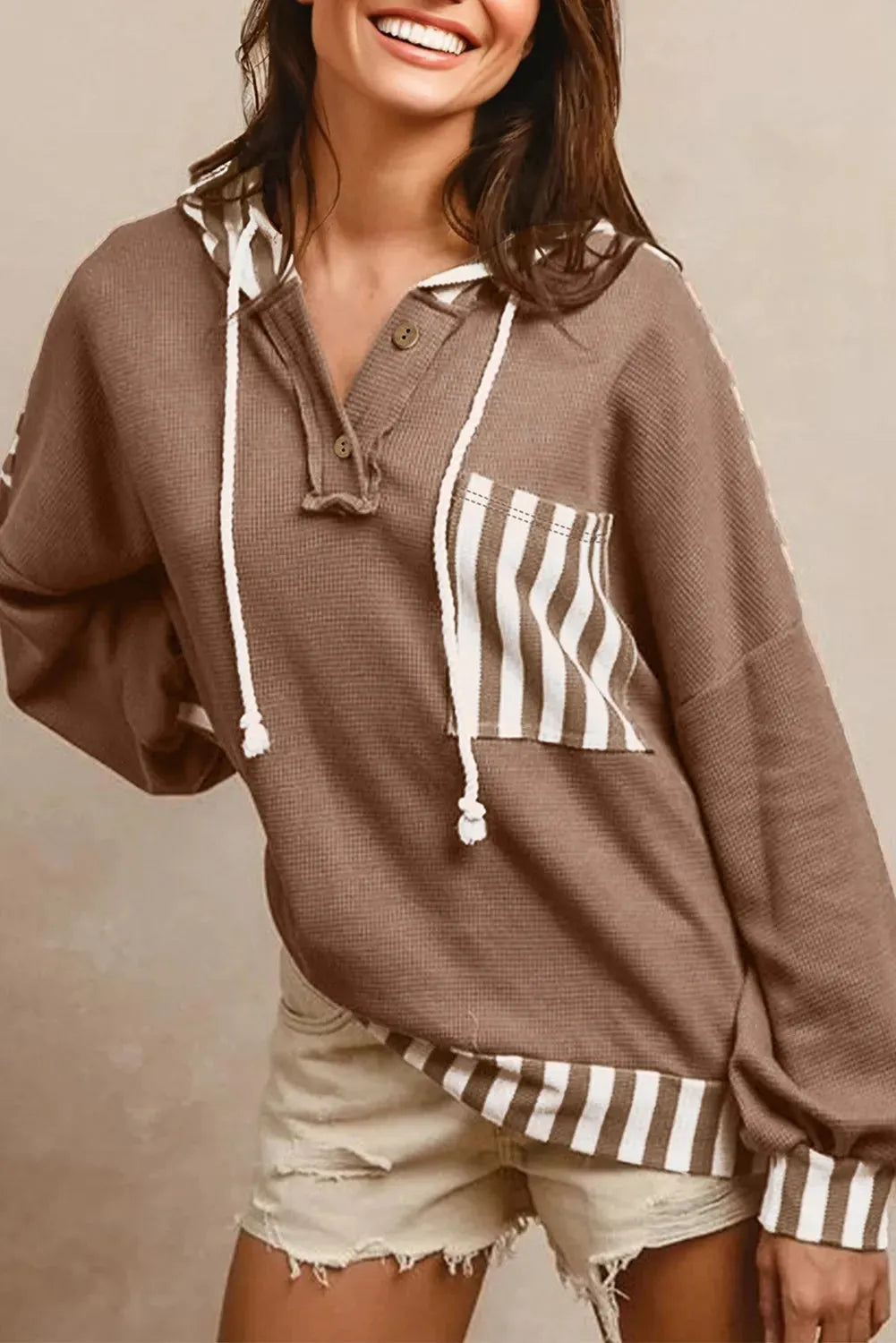 Straw yellow waffle texture hoodie with striped patchwork and a button-front drawstring neckline.