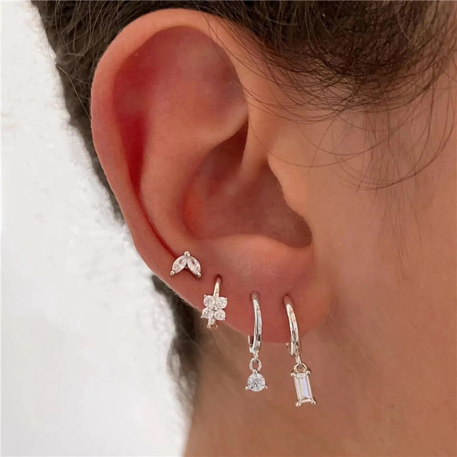 Four-piece set of geometric copper earrings with gold or silver plating, showing star and square shapes.