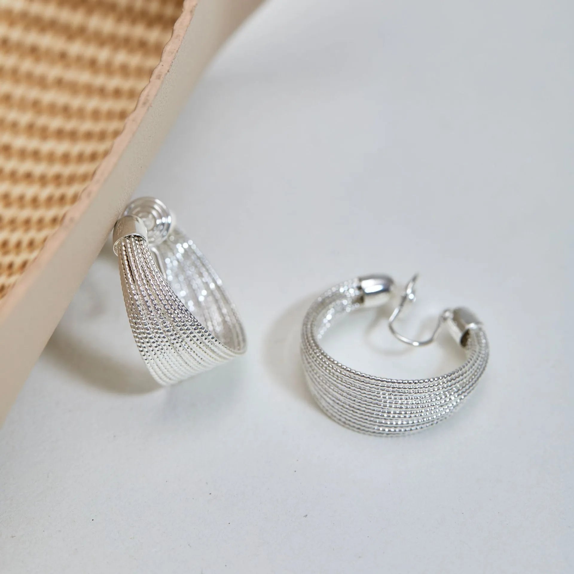 Set of four geometric earring pairs in silver and gold, including stud and clip styles