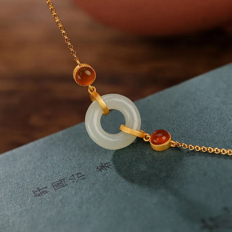 Gold-coloured women's bracelet with a sterling silver base and an inlaid natural Hetian jade peace symbol buckle.