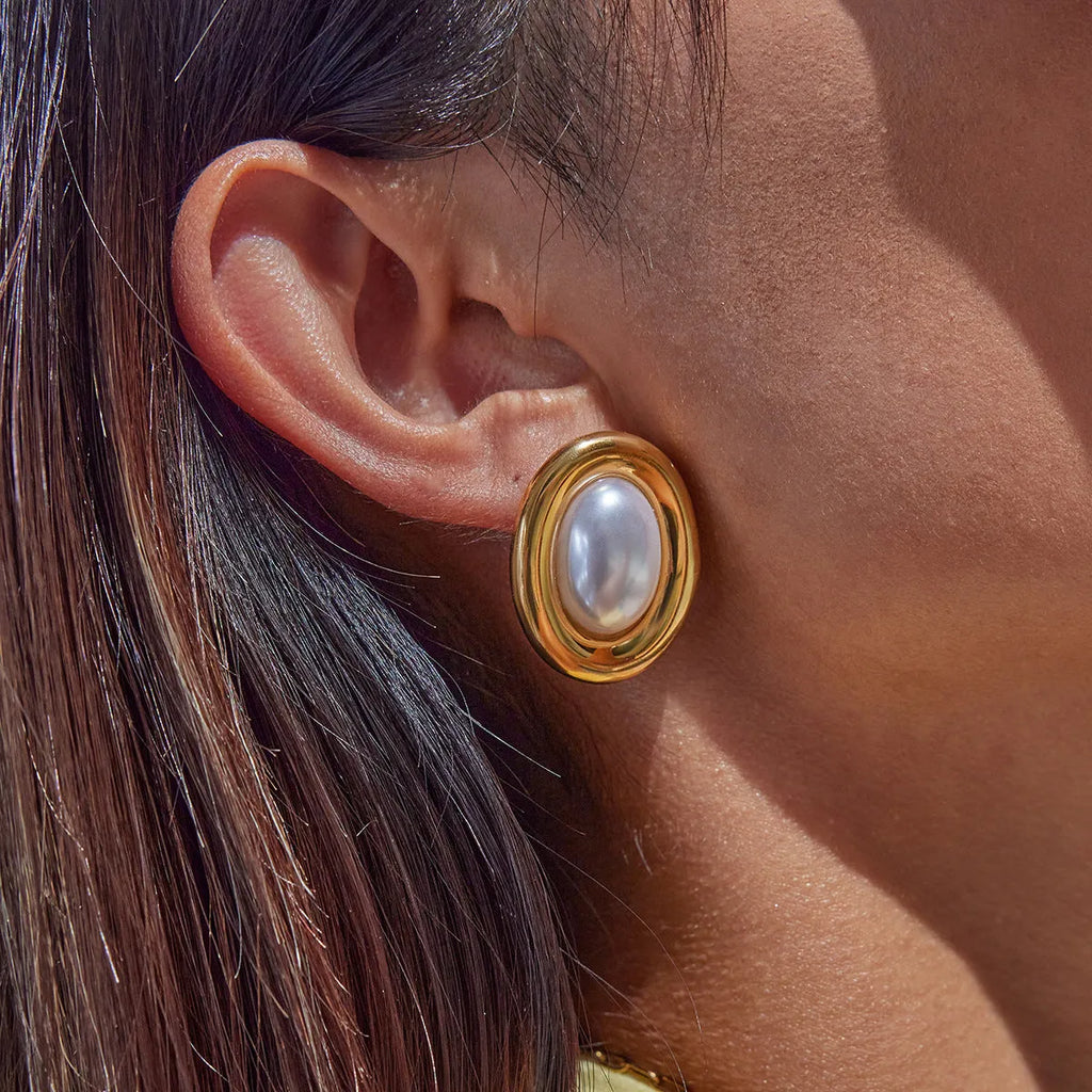 A pair of stainless steel vintage pearl ball stud earrings with surgical steel posts on a white background.