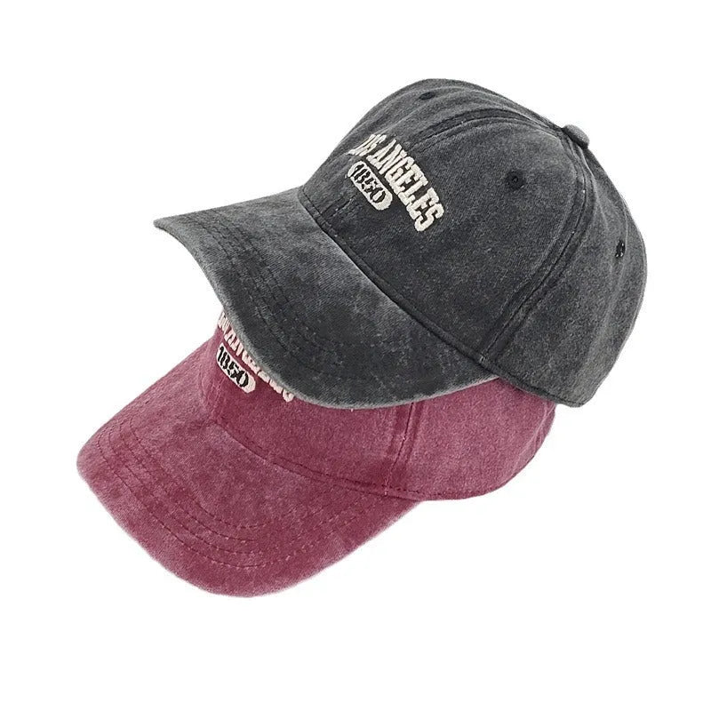 Personalised retro-style peaked cap with embroidered letters on distressed fabric in beige colour.