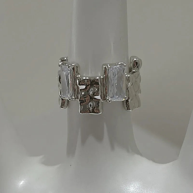 Silver geometric cross ring with open gemstone setting and retro national fashion decorative elements.