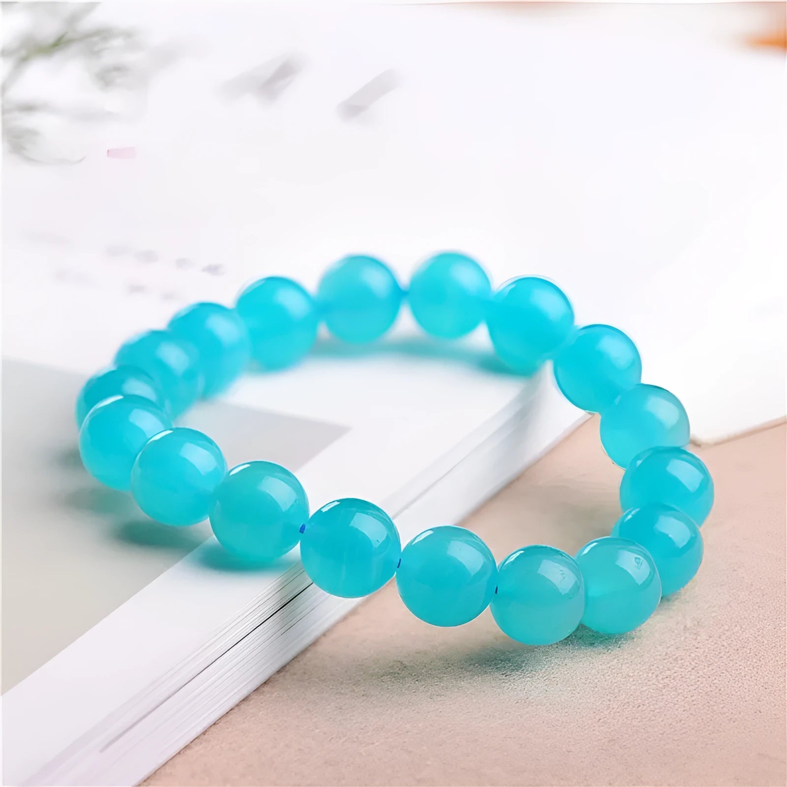 Natural blue-green Amazonite scattered loose beads in various sizes next to a finished crystal bracelet.