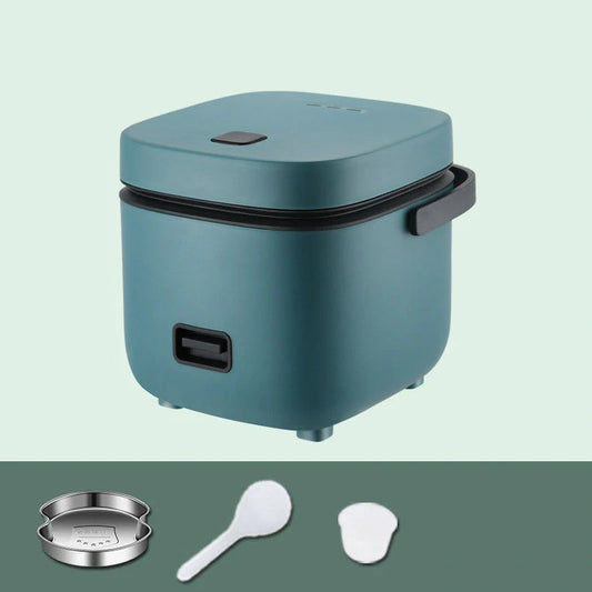 Green mini rice cooker with steaming plate and accessories on kitchen counter