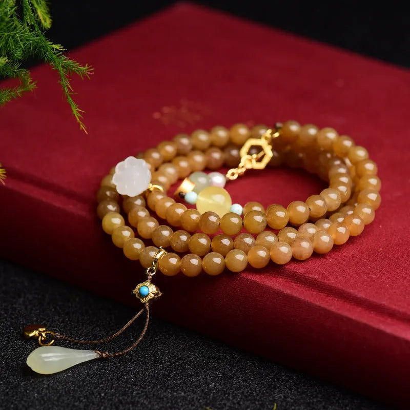 Green jade bead bracelet with leaf shapes and sequins on wrist