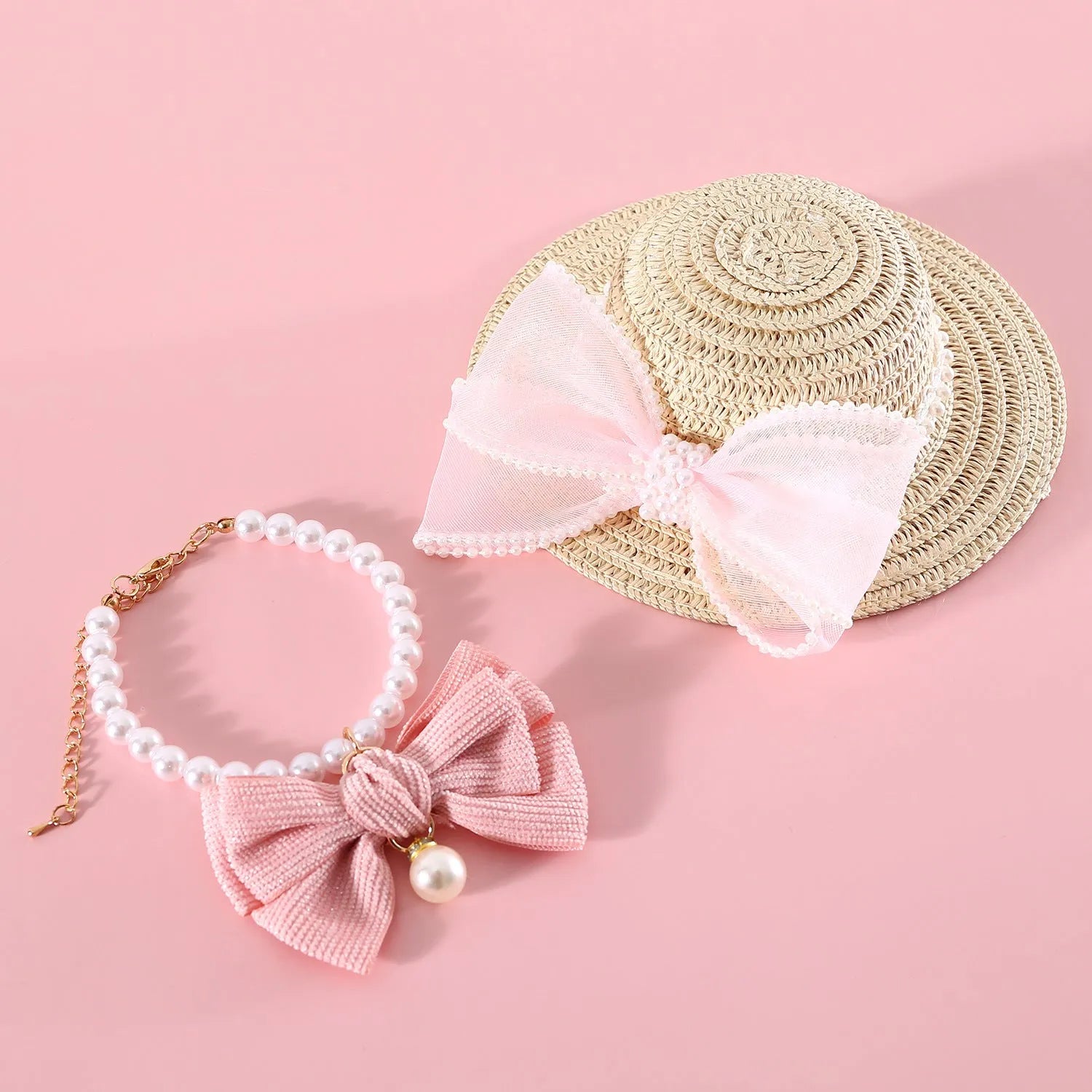 Pink pearl bow straw hat for a cat on a mannequin head, showing Lafite leaf weave and butterfly detail.